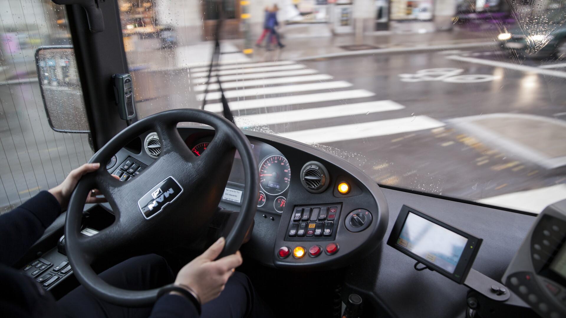 Bussförare kör buss vid ett övergångsställe